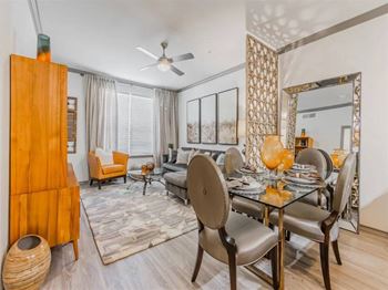 A modern dining room with a glass table and chairs.